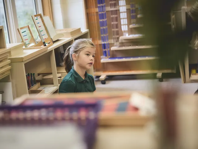 A student working with Montessori bead materials in the classroom