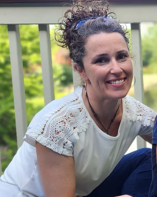 Cathy King, Co-Founder and Director of Education, smiling outdoors
